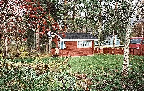 Kleines rotes Gästehaus im herbstlichen Garten